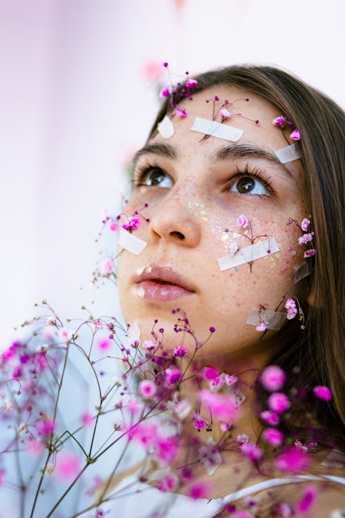 Girl With Pink Flowers on Face Taped with White Band Aid