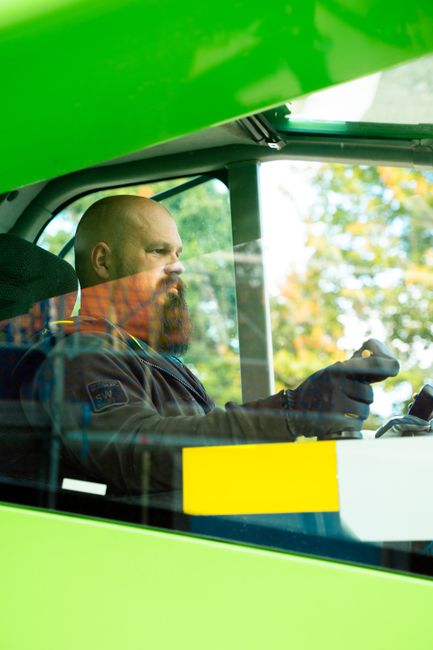 Mid adult caucasian man with a beard operating a construction vehicle through a window