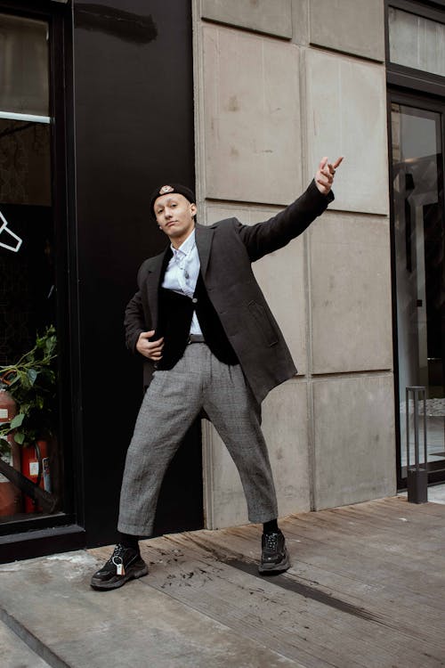 Free A Man in Black Suit and Gray Pants Standing Beside the Building Stock Photo