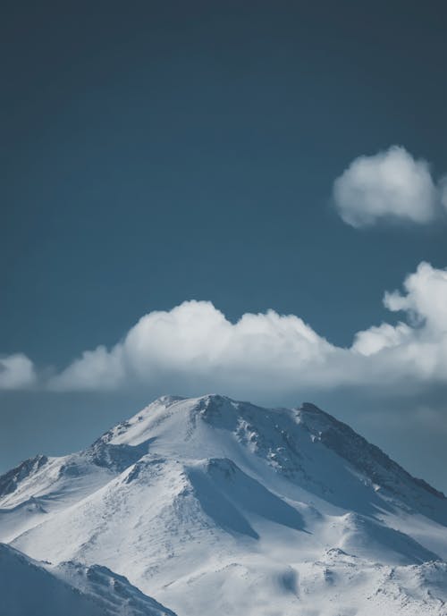 Snow Covered Mountain Under White Clouds