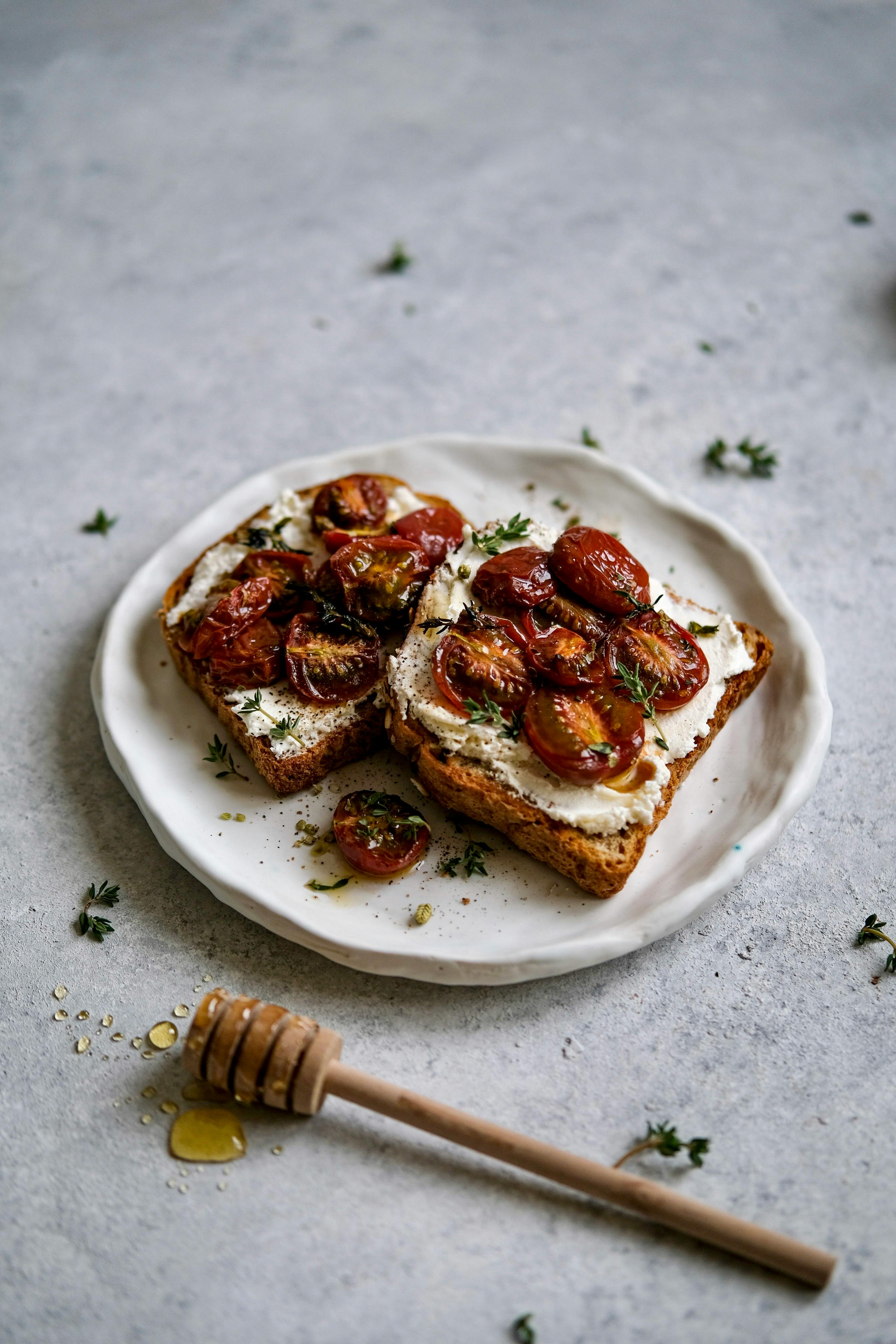 Delicious toast with roasted cherry tomatoes and honey, captured in a rustic setting.