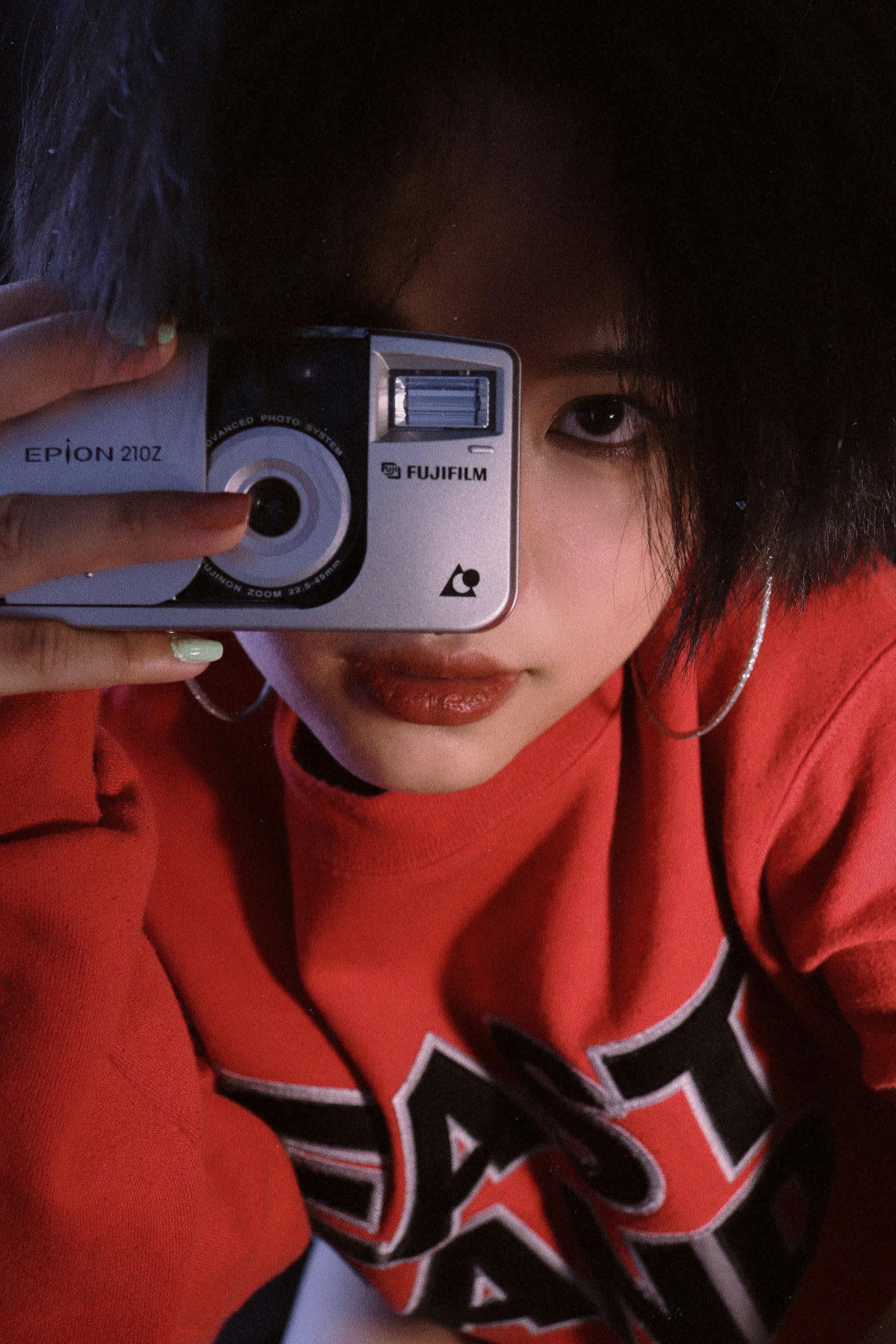 Portrait of a young woman in Vietnam holding an analog camera