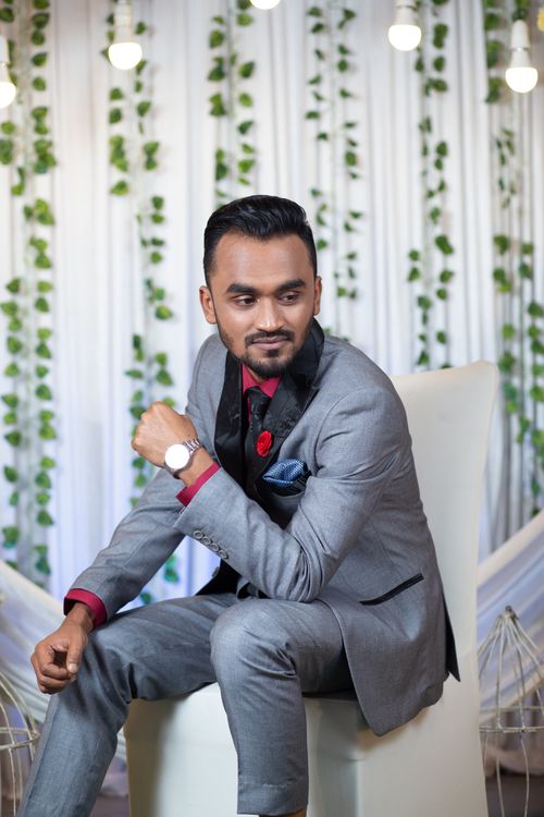 Free Sophisticated portrait of a well-dressed man in a suit sitting indoors. Perfect for fashion and lifestyle themes. Stock Photo