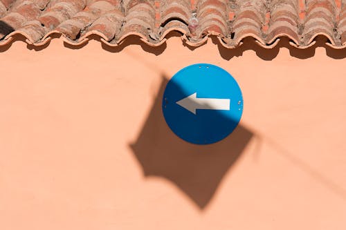 Directional Sign Hanging Under a Tiled Roof