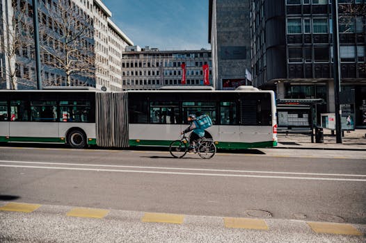 A bicycle courier rides past a bus on a bustling street in Ljubljana, Slovenia.
