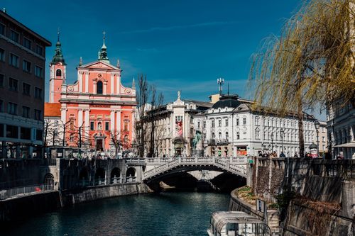 Free Explore Ljubljana's iconic Triple Bridge and vibrant Franciscan Church, nestled in the charming old town by the river. Stock Photo