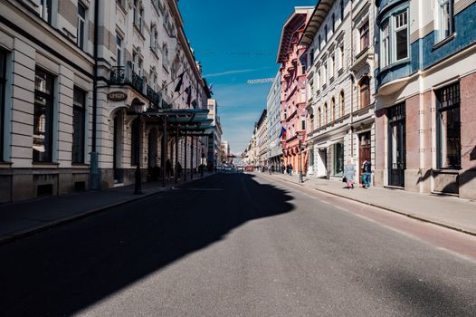 A vibrant street view showcasing historic architecture in Ljubljana, Slovenia under a clear blue sky.