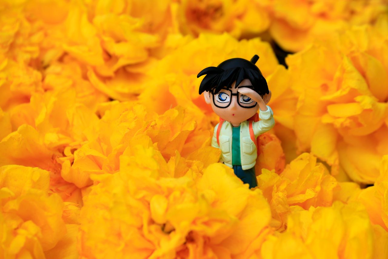 a detailed figurine stands among vivid yellow flowers capturing a play