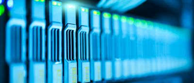 A close-up view of modern server blades with glowing blue and green indicator lights in a high-tech data center.