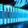 A row of modern server racks glowing with blue and green lights in a datacenter.
