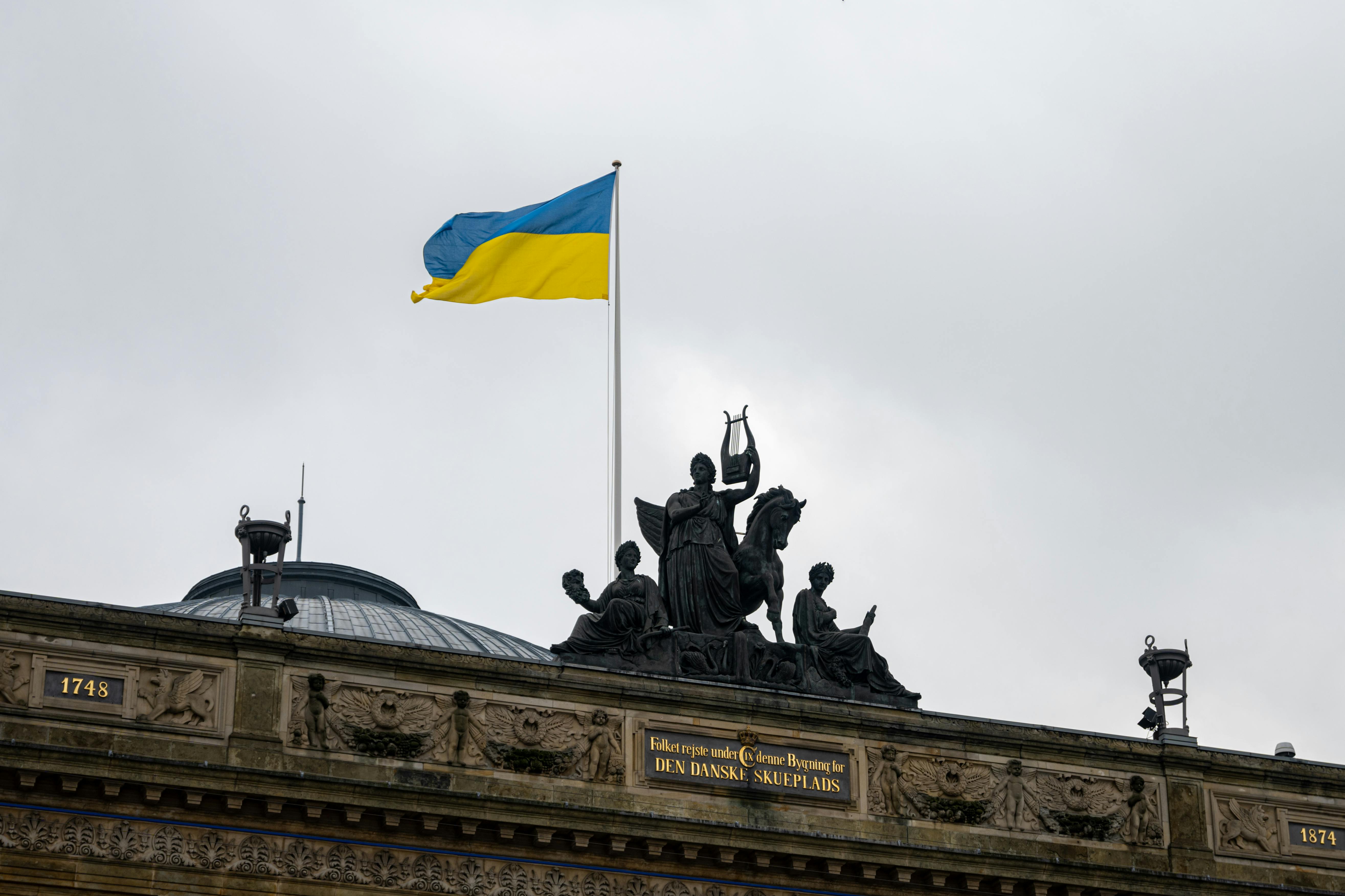 Ukrainian flag flying above a Danish architectural landmark in Copenhagen, symbolizing peace.