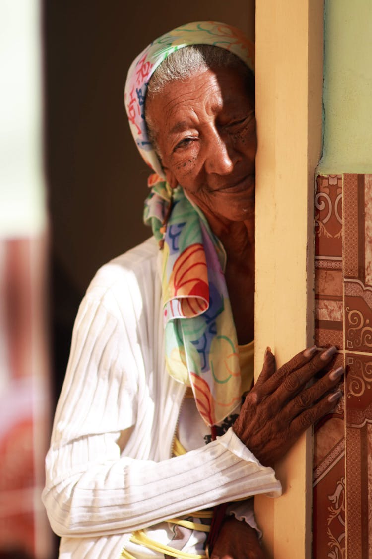 Elderly Woman In Kerchief Looking From Behind Corner