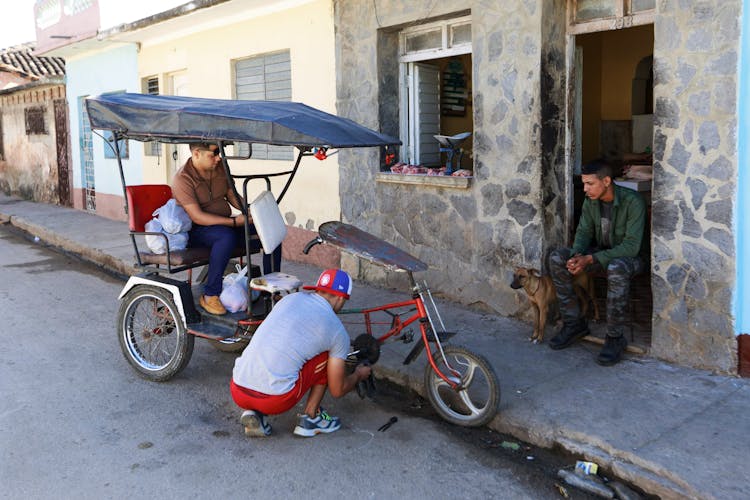 Men Cleaning Bicycle In Town