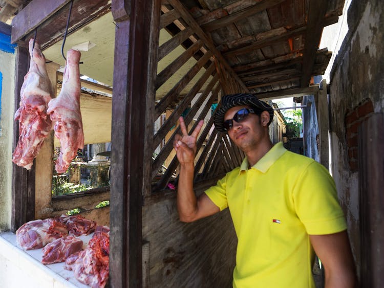 A Man Standing Beside The Meat Shop