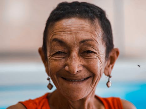 Close-up of a smiling senior woman with short hair and earrings.