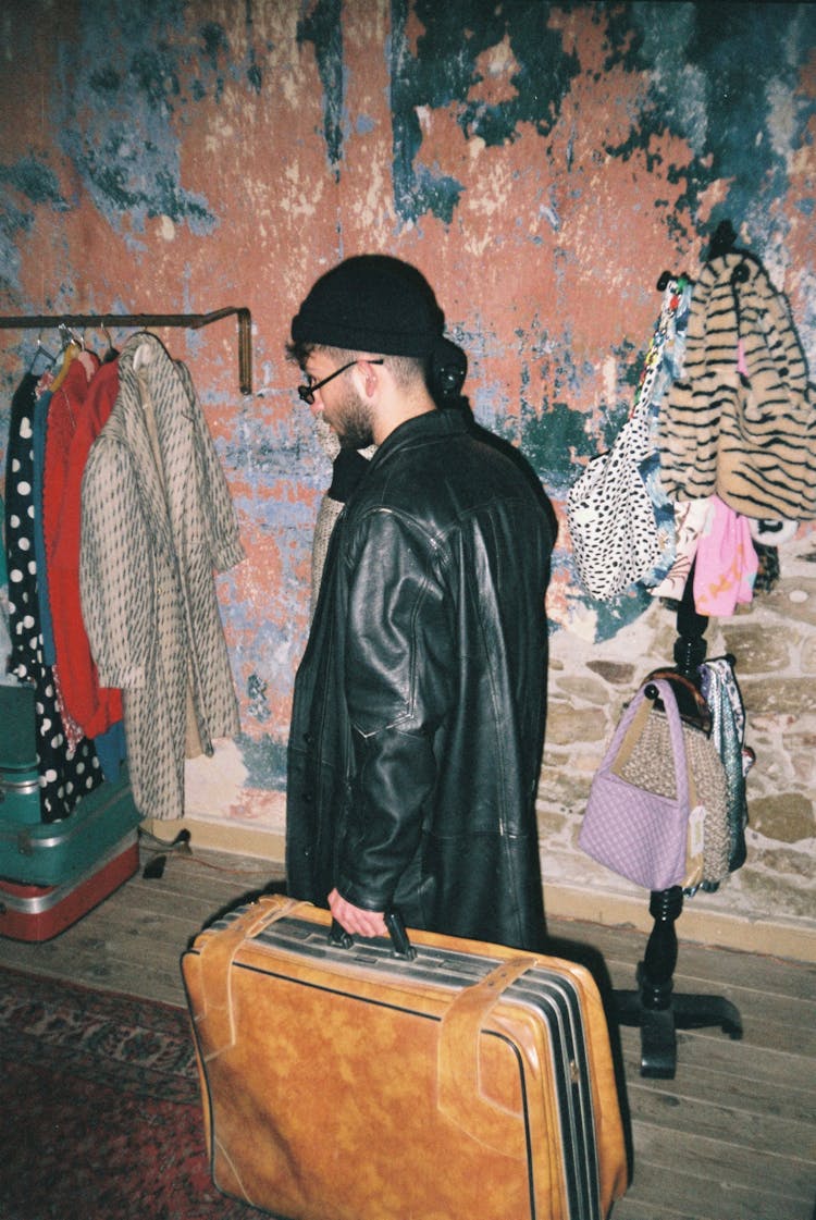 Man In Beanie And Sunglasses Carrying Suitcase