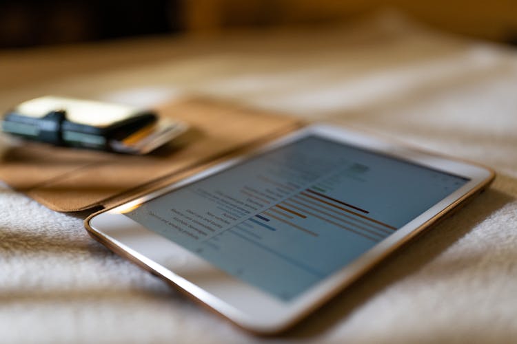 Close-Up Shot Of A White Ipad On White Textile