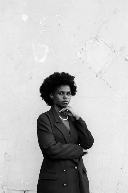 Black and white portrait of an African American woman with afro hair wearing a blazer.