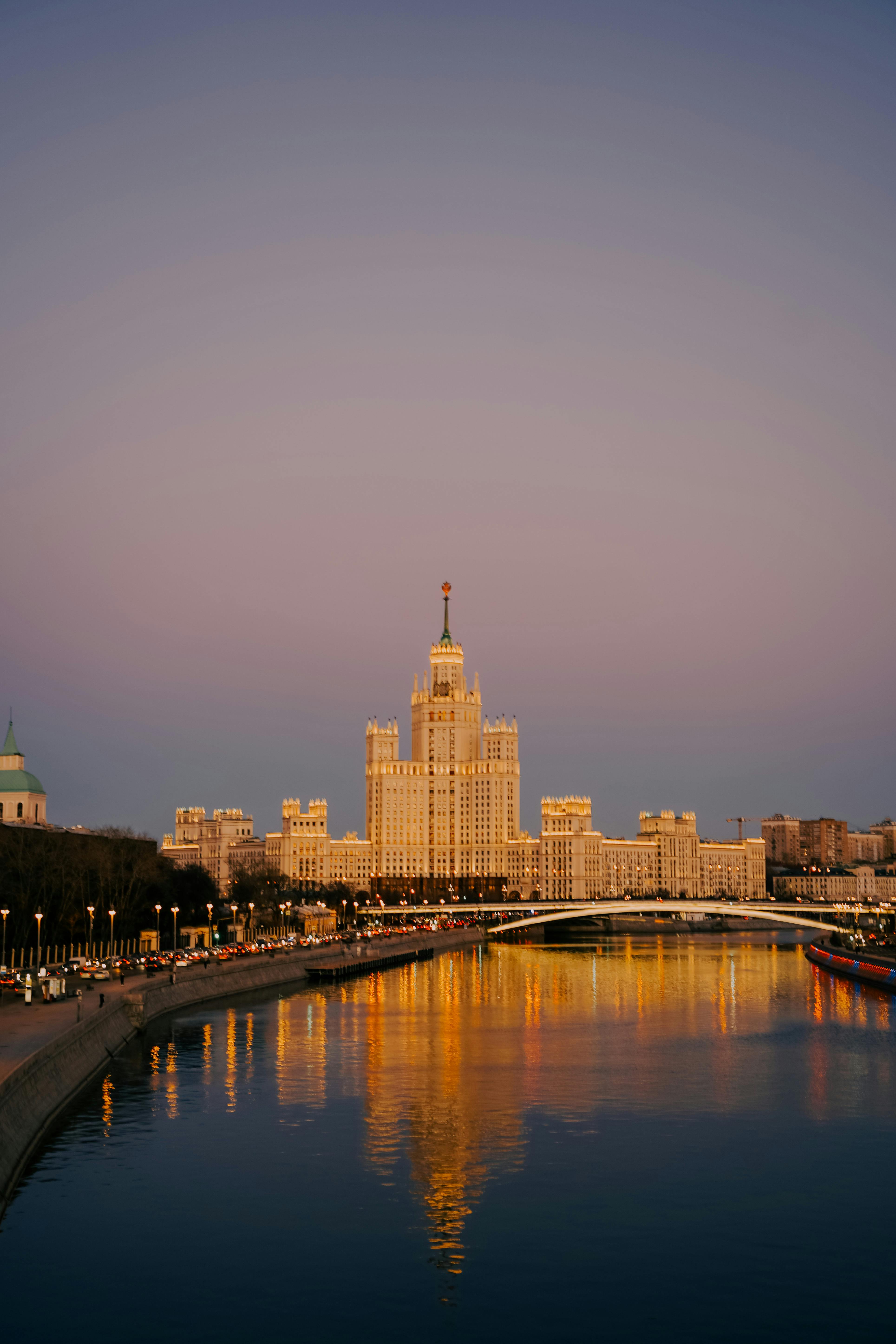 A breathtaking view of Moscow's skyline at sunset with vibrant reflections in the Moskva River.
