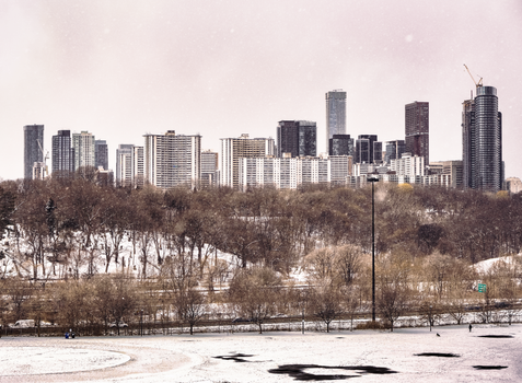 Aerial view of Toronto skyline during winter with a snowy park in the foreground.