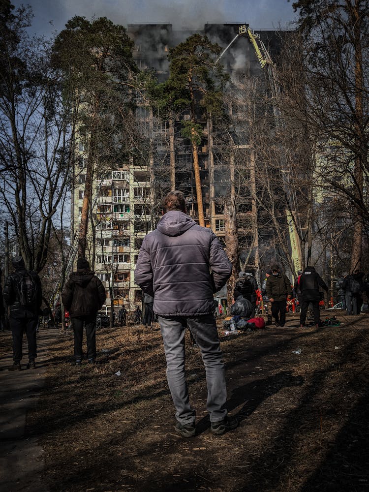 People Looking At Burnt Building