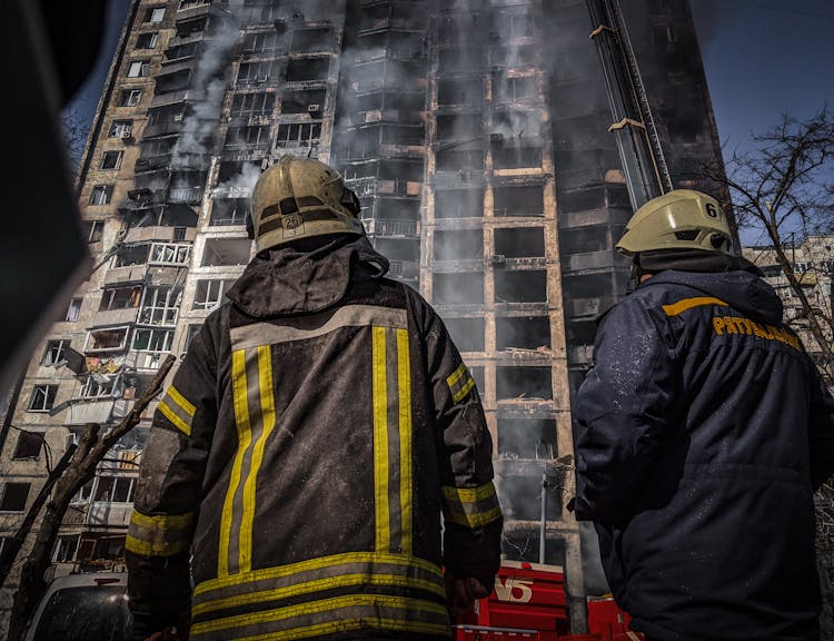 Firefighters Looking At Burnt Building