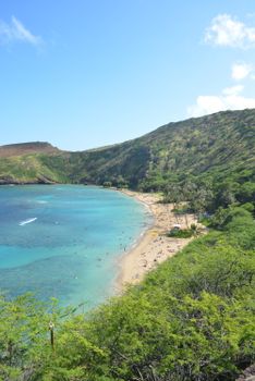 Photo by Nik Cvetkovic A breathtaking view of Hanauma Bay's clear blue waters, pristine beach, and lush green cliffs in Hawaii.