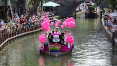 乌得勒支运河游行丰富多彩，粉色气球、船只和热闹的人群共同沉浸在节日的欢乐气氛中