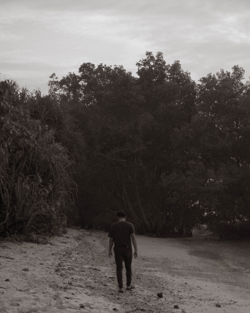 Free A solitary figure walks along the sandy shores of Sukabumi, Indonesia, captured in monochrome. Stock Photo