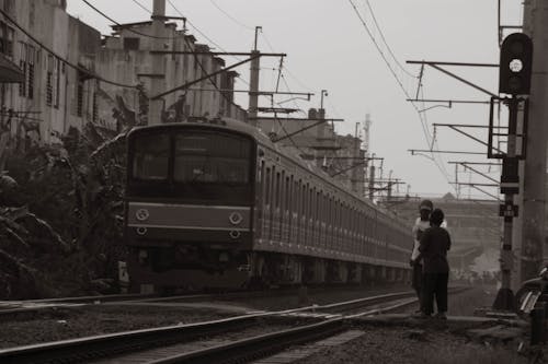 Grayscale Photo of People Standing Near a Train