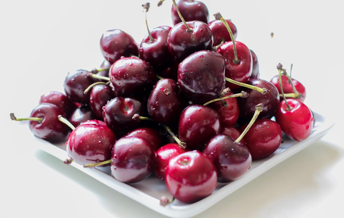 Cherries in White Ceramic Plate