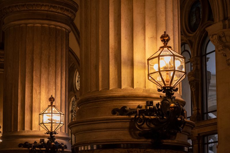 Moody interior of a Hamburg cathedral with illuminated columns and lanterns.