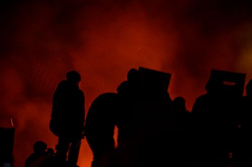 Free Silhouetted figures against a red, smoky backdrop, creating a dramatic nighttime atmosphere. Stock Photo