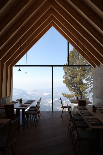 Chic restaurant with panoramic mountain views in Obereggen, Italy.