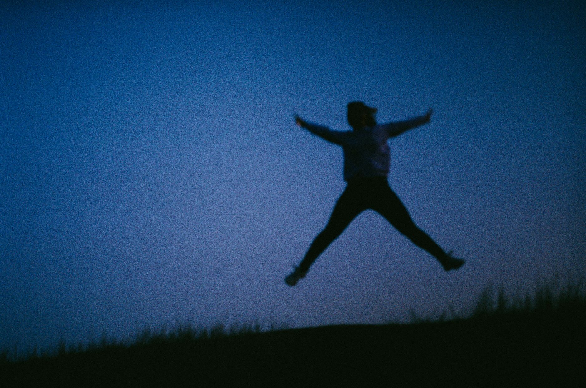 long covid fatigue natural remedies — A striking silhouette of a person leaping against a twilight horizon, evoking freedom.