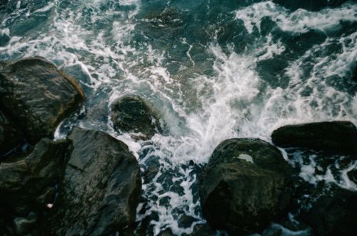 Free Energizing view of ocean waves crashing over coastal rocks, perfect for nature and travel themes. Stock Photo