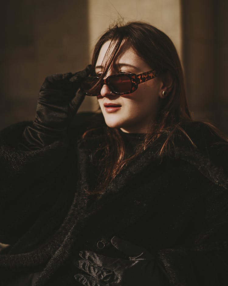 Brunette Woman In Black Furry Coat Looking Over Sunglasses