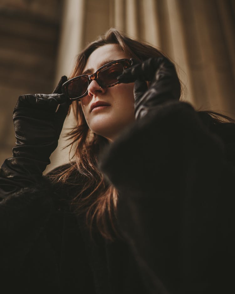 Woman In Black Furry Coat And Gloves Looking Down Through Sunglasses