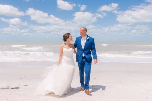 A Newlywed Couple Walking on the Seashore