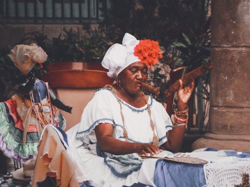 Free A woman in traditional attire smokes a cigar outdoors, embodying vibrant culture. Stock Photo
