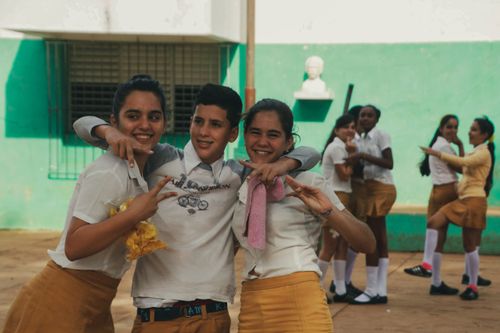 Free Group of teenagers in school uniforms posing and smiling, capturing youthful energy and friendship. Stock Photo