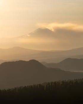 Breathtaking sunrise over misty mountains near Mexico City, with clouds enhancing the serene landscape.