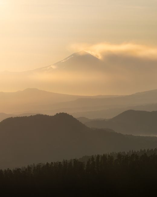 Breathtaking sunrise over misty mountains near Mexico City, with clouds enhancing the serene landscape.
