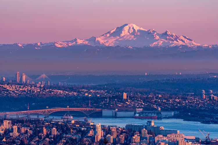 Panorama Of City At Foot Of High Mountains