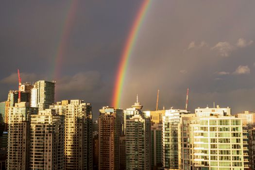 Stunning aerial view of Vancouver skyline with a vivid double rainbow.
