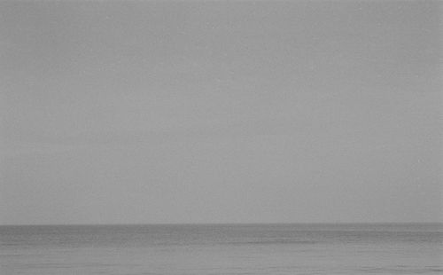 Free A serene black-and-white seascape capturing the calm ocean horizon. Stock Photo