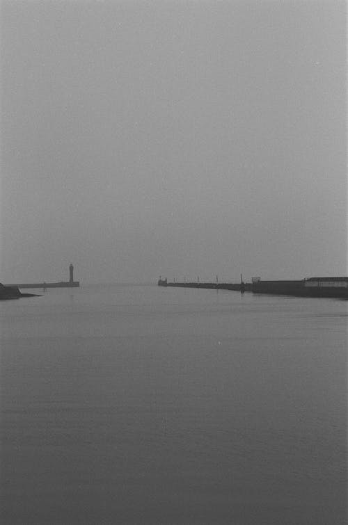 Grayscale Photo of Docks on Sea