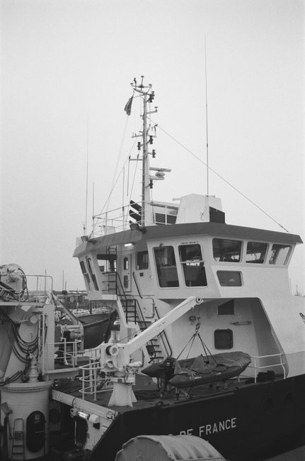 Black and white image of a docked maritime vessel emphasizing nautical design.