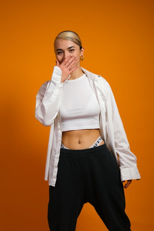 Woman in a White Crop Top Covering Her Mouth