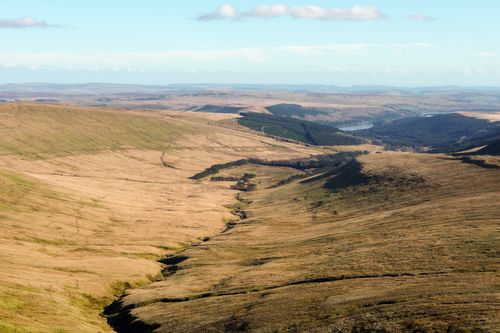 Free A stunning aerial view of expansive rolling hills and valleys with a clear blue sky. Stock Photo